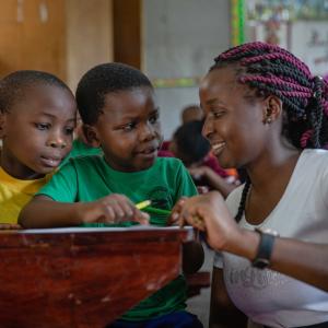 A teacher helping students at a desk