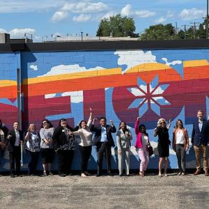 Group of people stand in front of a large wall mural in Sisseton, South Dakota