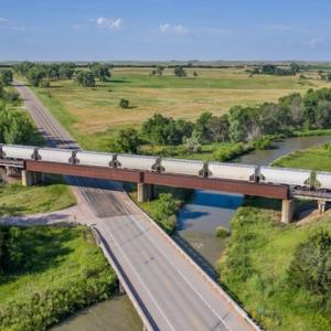 Train traveling on track through verdant landscape