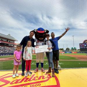 Slow Roll Buffalo donation shown with Buffalo Mascot and a family.