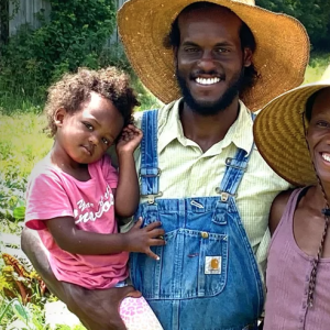2 parents smile while holding their child