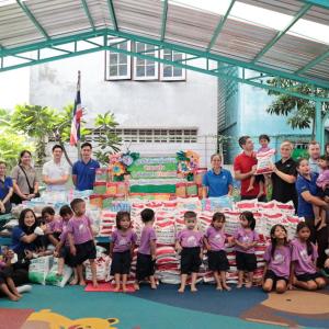Adults and young children stood around bags of donation bags