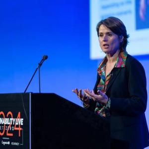 A person on stage talking into a microphone 