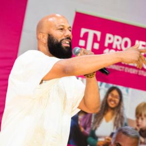 A person talking in to a microphone while pointing 