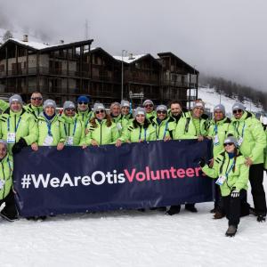 Group of Otis volunteers holding a We Are Otis banner.