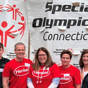Henkel employees standing before Special Olympics Connecticut banner