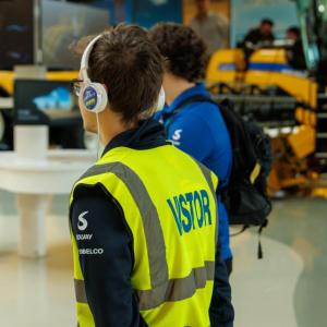 A person wearing a hi-vis vest and earphones 