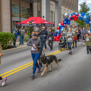 Race participants at the starting line, a balloon archway marking the start.
