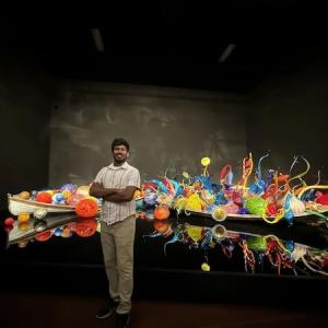 Srinivasa Rao Aharma shown in front of a traditional Indian vessel.