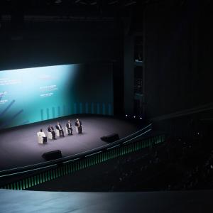 Five people sat on chairs on a stage 