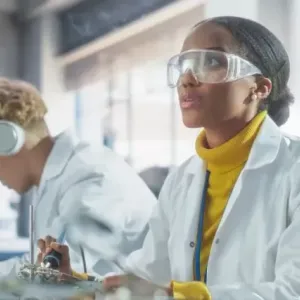Students in protective lab gear working on projects
