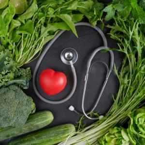 A stethoscope and a small heart are shown with produce.