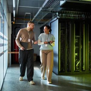 Two workers walking through a data center
