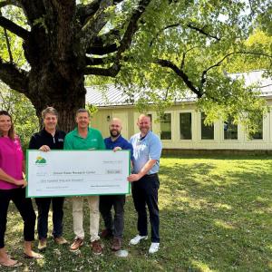 Group of Stroud Water Research Center team and Green Mountain Energy team pose with a $141,000 sustainability grant check at Stroud Water Research Center facility in Avondale, PA.
