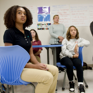 Students sat on blue chairs 