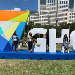 people standing in front of "GHC" statue
