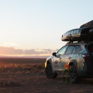 A parked car facing towards the sun setting