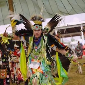 people wearing traditional clothing, crafted from beads and feathers