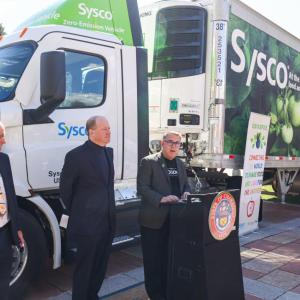 People standing by the side of a truck