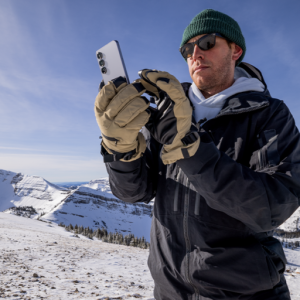 Jimmy Chin looking at phone on mountaintop