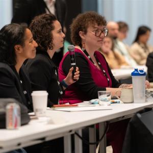 Three attendees engage in discussion at Sustainability LIVE Chicago 2025, with one woman holding a microphone.
