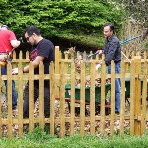 Henkel employees inside an enclosed fenced area with outdoor tools