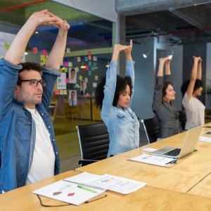 people at conference table stretching