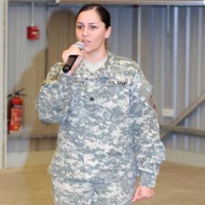 Marsha Smith talking into a microphone wearing a military uniform 