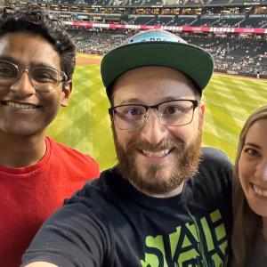 Tanishq and two friends at a baseball game.
