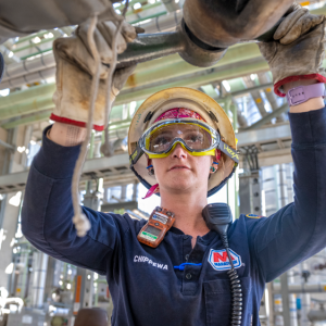 Tara Chippewa turning a part on an industrial pipe.