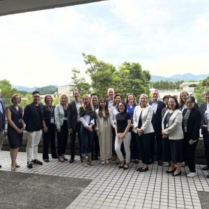 A team of people posed outside a building.