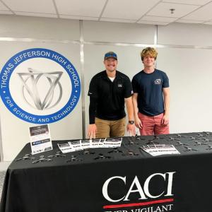 Two people standing behind a table
