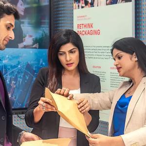Three people talking, looking at documents