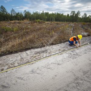 Terri measuring a pole on the ground