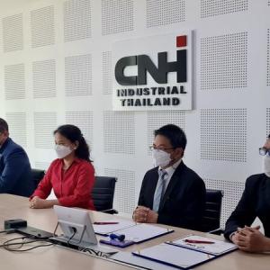 group of people all wearing protective masks sit at a conference table with CNHI sign behind them