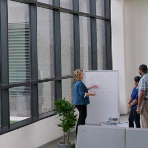 three people in front of a whiteboard