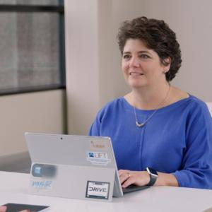 Lynn Penny sitting in front of her laptop