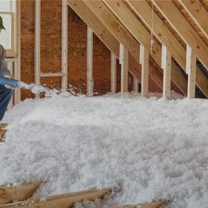 ENERGY STAR: Rule your attic. Worker shown blowing in insulation into an attic space.