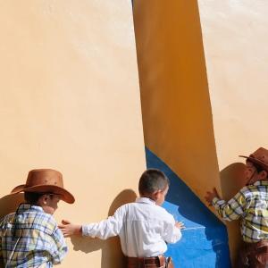 Thomas Allison photograph of three children playing; dressed as cowboys.