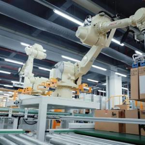 A robotic arm lifting a box in a large facility