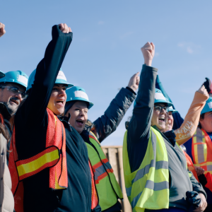 Group of people raising their arms and cheering.