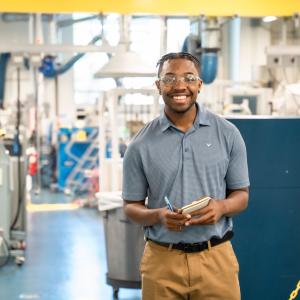 A person shown smiling in a warehouse.