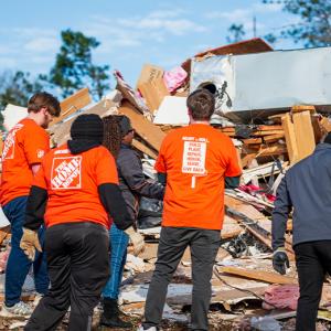 Destruction by a tornado shown. Members of Team Depot shown at the disaster site.