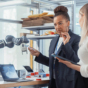 two women standing with robotic equipment