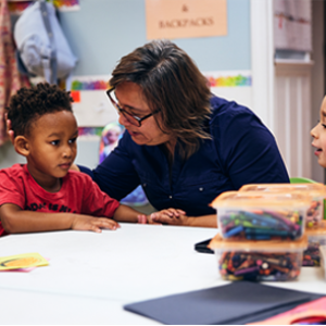 woman sitting with two small children at table