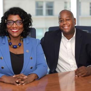 Two people sat next to each other smiling 