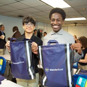 two students holding Webster Bank bags