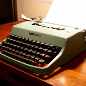 A light green typewriter on a table top