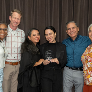A group of people stood together for a photo holding an award