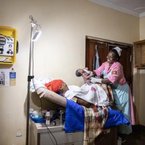 Health worker delivering baby in hospital, Uganda